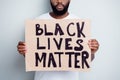 Stop violence concept. Cropped photo of disappointed dark skin african protester placard community against black