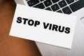 STOP VIRUS inscription on white paper note on laptop keyboard. Goodbye coronavirus. Closeup