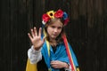 Stop war in Ukraine.Blond crying girl with Ukrainian flag showing stop with her hand.Peace in Ukraine concept.
