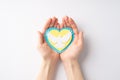 Stop the war in Ukraine concept. Top overhead view photo of female hands holding yellow and blue heart with white dove silhouette Royalty Free Stock Photo