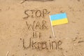 Stop the war in Ukraine and next to it lies the flag of Ukraine written in the sand on the banks of the Dnieper River in Ukraine,