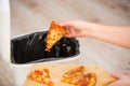 Stop wasting food, Woman hand throwing some food, pizza pieces to the bin, trash, food concept Royalty Free Stock Photo