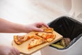 Stop wasting food, Woman hand throwing some food, pizza pieces to the bin, trash, food concept Royalty Free Stock Photo