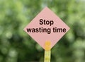 Stop wasting time - text on a pink piece of paper on notes on a green background. Copy space for your design Royalty Free Stock Photo