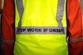 `Stop work if unsafe` on reflective vest for worker.