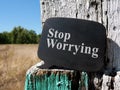 Stop worrying phrase on the wooden plate.