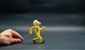 Stopmotion process of walking. Third step. Man\'s hand holding with an aluminum wire a figure made with yellow modeling paste Royalty Free Stock Photo