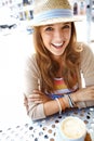 Stopping off for a cup of coffee. A happy young woman smiling at the camera while sitting at a sidewalk cafe in the city