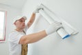 Painter with putty knife. Plasterer smoothing wall surface at home renewal