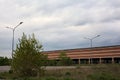 Stopping place with street lamps next to an abandoned warehouse on a cloudy day in the italian countryside