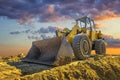 A stopping yellow excavator at a beautiful sunset