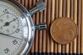 Stopwatch and coin with a denomination of 5 euro cents on wooden table background Royalty Free Stock Photo