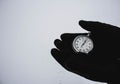 A stopwatch in hand. Black gloves on a white background. Ancient stopwatch