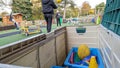 A storage box full of sports equipment being played with by mother and daughter