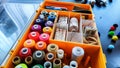 Storage box with spools of multi-colored threads, sewing needles. Storage system for sewing needlework at home Royalty Free Stock Photo
