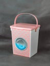 Storage container for washing powder in the form of a washing machine on a dark background