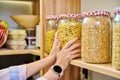 Storage of food in the kitchen in pantry, woman's hands with a can of corn flakes Royalty Free Stock Photo