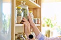 Storage of food in the kitchen in pantry, woman& x27;s hands with a can Royalty Free Stock Photo