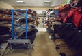 Storage room with rows of shelves full of fabric and leather rolls at footwear factory