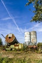 Storage yard and scrap collecting area for old agricultural equipment, silos, tractors and other scrap around barn and warehouse Royalty Free Stock Photo