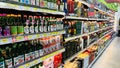 A store aisle with many bottles of drinks, including some Asian drinks