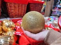 In the store choose Christmas balls, a New Year's golden ball in your hand Royalty Free Stock Photo