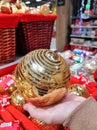 In the store choose Christmas balls, a New Year& x27;s golden ball in your hand Royalty Free Stock Photo