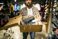 Store clerk helping customer try hiking boots at outdoors equipment shop. Salesman demonstrating trekking and hiking