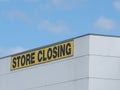 Store Closing black on yellow letters on a white claded industrial building