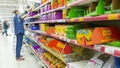 A store employee lays cat food on shelves.