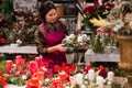 Store employee makes Christmas composition with candles