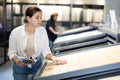 in store,female buyer carefully examines laminate sample. Woman chooses flooring material