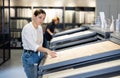 in store,female buyer carefully examines laminate sample. Woman chooses flooring material