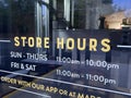Store hours sign on a glass door