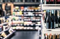 Store for liquor and alcohol. Sparkling wine bottle for sale in shop. Shelf and aisle in background.