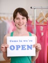 Store owner holding open sign