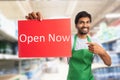 Store owner presenting open now sign