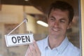 Store Owner Turning Open Sign In Shop Doorway Royalty Free Stock Photo