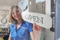 Store Owner Turning Open Sign In Shop Doorway Royalty Free Stock Photo