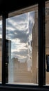 Storefront window reflecting a cityscape view. The reflection shows a cloudy sky with patches of Royalty Free Stock Photo