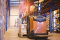 Storehouse area, Shipment. Electric forklift pallet jack unloading pallet goods in warehouse storage. Royalty Free Stock Photo