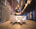 Speeding motion of warehouse worker unloading pallet goods in warehouse storage, his using forklift pallet jack. Royalty Free Stock Photo