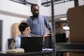 Storehouse delivery team looking at metallic box checking package order while working at packaging production Royalty Free Stock Photo