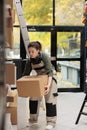 Storehouse employee putting cardboard boxes on shelves