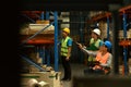 Storehouse employees workers in hardhats and and vests working together in warehouse. Logistics, and manufacture Royalty Free Stock Photo