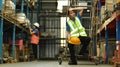 Storehouse employees workers in hardhats and and vests working together in warehouse. Logistics, and manufacture Royalty Free Stock Photo