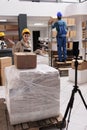 Storehouse worker recording package packing educational tutorial in warehouse