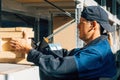 Storekeeper lays out boxes on racks in warehouse. Caucasian worker at work in sorting warehouse. Authentic portrait on Royalty Free Stock Photo