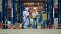 Storeman checking operation of robot pulling a cart