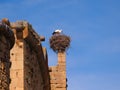 a stork nest perched on a brick building next to a steep wall Royalty Free Stock Photo